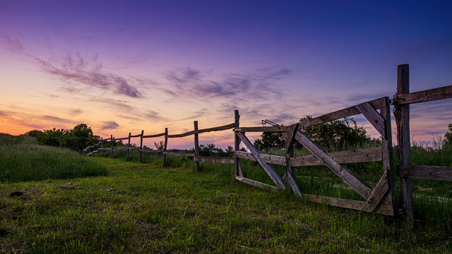 Blue-colored twilight, old wooden fence in the foreground