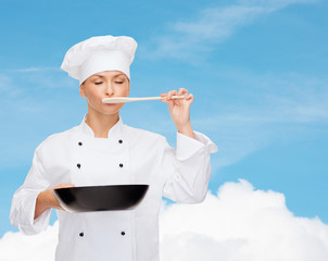 smiling female chef with pan and spoon
