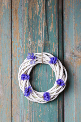 White wicker wreath decorated with cornflowers