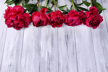 Beautiful pink peonies on color wooden background