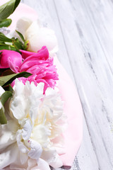 Beautiful pink and white peonies on color wooden background