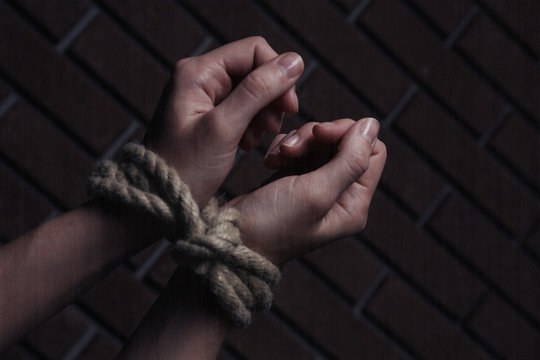 Tied hands on dark background