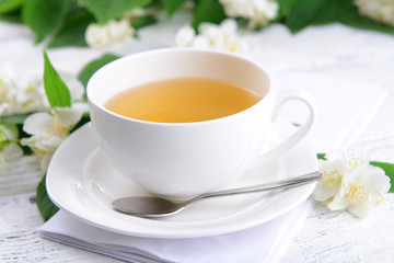Obraz na płótnie Canvas Cup of tea with jasmine on table close-up