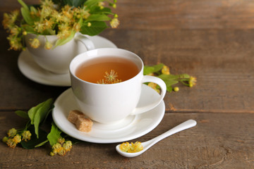Tasty herbal tea with linden flowers on wooden table