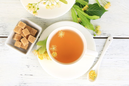 Tasty herbal tea with linden flowers on wooden table