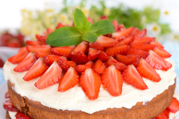 Delicious biscuit cake with strawberries on table close-up