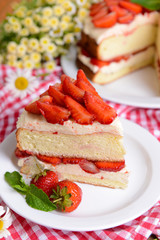 Delicious biscuit cake with strawberries on table close-up