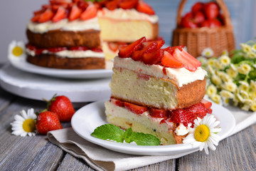 Delicious biscuit cake with strawberries on table close-up