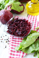 Grated beetroots in bowl on table close-up