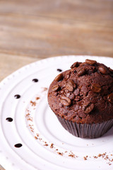 Chocolate muffin on plate wooden background