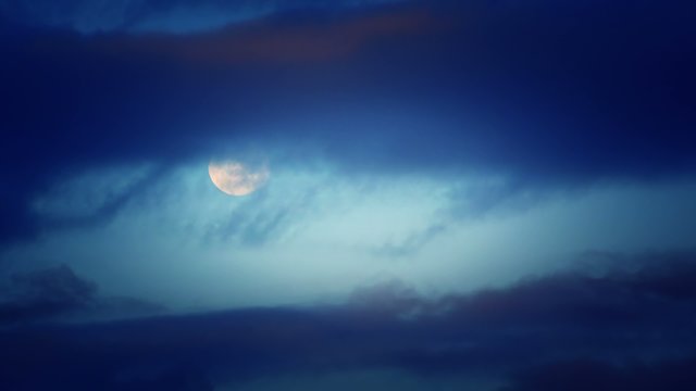 moon behind flying clouds