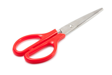 Red scissors on white background