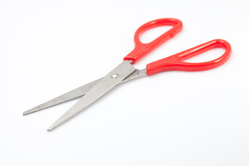 Red scissors on white background