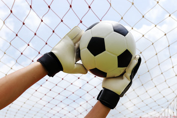 goalkeeper's hands reaching for foot ball