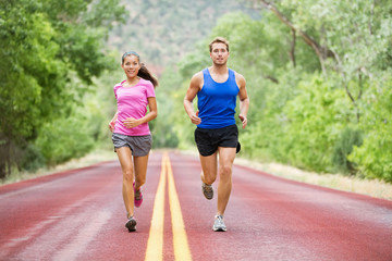 Running young couple outside jogging happy smiling