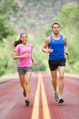 Running people - two smiling runners jogging