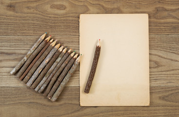 Vintage Pencils and Aged Paper on Rustic Wood
