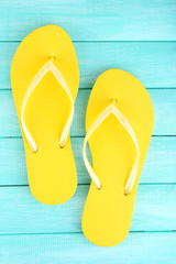 Bright flip-flops on color wooden background