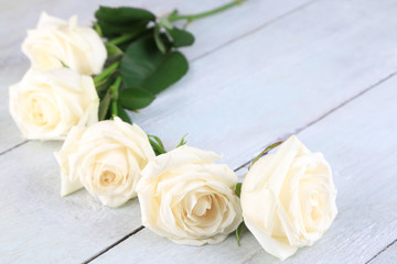 Beautiful white roses on wooden table