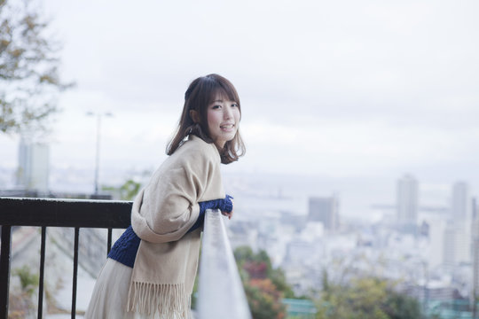 展望台から神戸の景色を望む笑顔の女性