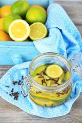 Pickled limes and cloves in glass jar,