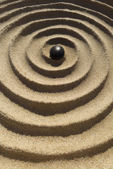 Fototapeta na wymiar Zen Spirale mit Kieselstein im Hochformat