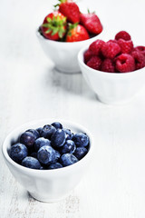 Berries in bowls  on Wooden Background.