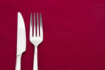 Knife and fork on red tablecloth