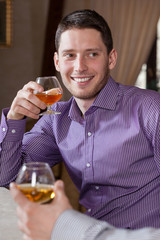 Fototapeta premium Man drinking cognac with friend