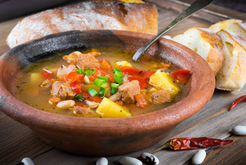 .Hungarian goulash with beans and peppers on wooden board © seqoya