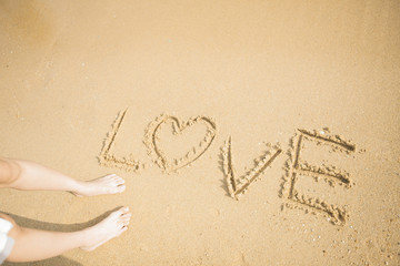 砂浜に文字を書く女性