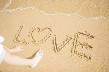 砂浜に文字を書く女性