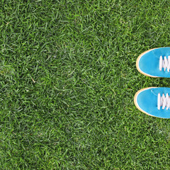 blue rubber sneakers on faded green grass