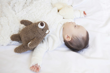 ぬいぐるみと眠る赤ちゃん