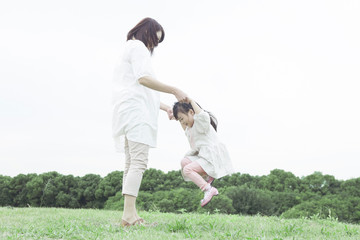 Fototapeta na wymiar 芝生で遊ぶ母と子