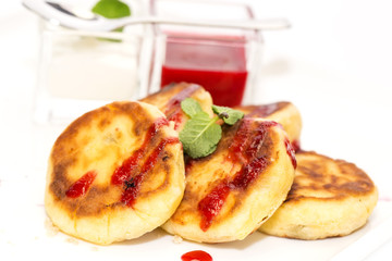 cheesecakes with sour cream and jam on table in restaurant