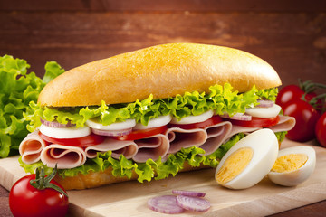 big sandwich with ham, cheese and vegetables