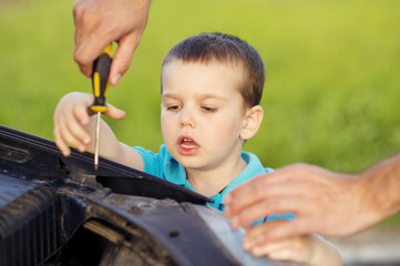 Father and son repairing car