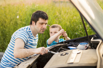 Father and son repairing car