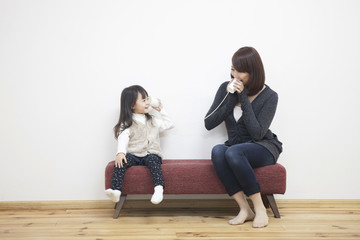 糸電話で遊ぶ母親と子供