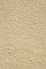 Yellow rough plaster on wall closeup