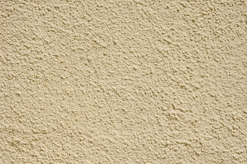 Yellow rough plaster on wall closeup