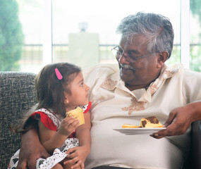 Grandparent and grandchild eating cake