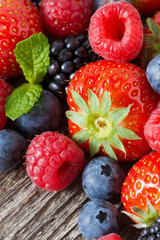 assorted fresh berries on wooden background, close-up, vertical