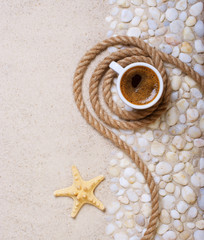 Fototapeta na wymiar Cup of coffee on the sea pebbles on beach party