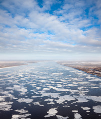 great river with floating ice floes, top view