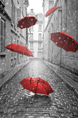 Red umbrellas flying on the street. Conceptual image - obrazy, fototapety, plakaty