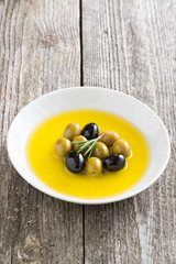 fresh olive oil and olives in a plate, vertical
