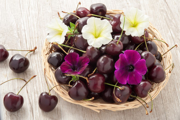 Cestino in vimini con ciliegie e fiori freschi