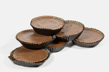 Pile of Six Brown Chocolates in Protective Papers